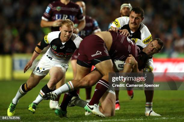 Lloyd Perrett of the Sea Eagles is tackled during the round 26 NRL match between the Manly Sea Eagles and the Penrith Panthers at Lottoland on...