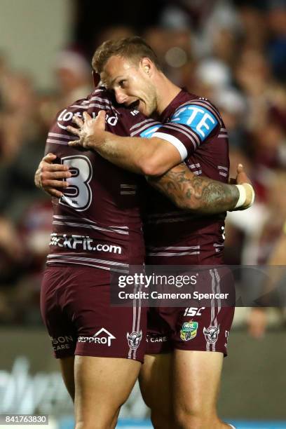 Daly Cherry-Evans of the Sea Eagles celebrates scoring a try with team mate Dylan Walker during the round 26 NRL match between the Manly Sea Eagles...