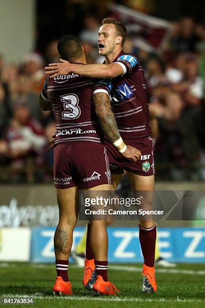 Daly Cherry-Evans of the Sea Eagles celebrates scoring a try with team mate Dylan Walker during the round 26 NRL match between the Manly Sea Eagles...