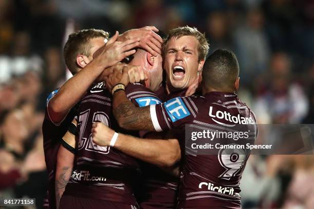 Curtis Sironen of the Sea Eagles celebrates scoring a try with Jake Trbojevic of the Sea Eagles and team mates during the round 26 NRL match between...