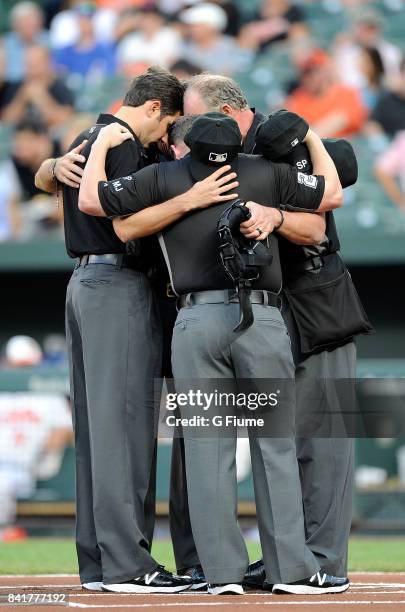 The umpire crew huddles up before the game between the Baltimore Orioles and the Oakland Athletics at Oriole Park at Camden Yards on August 22, 2017...