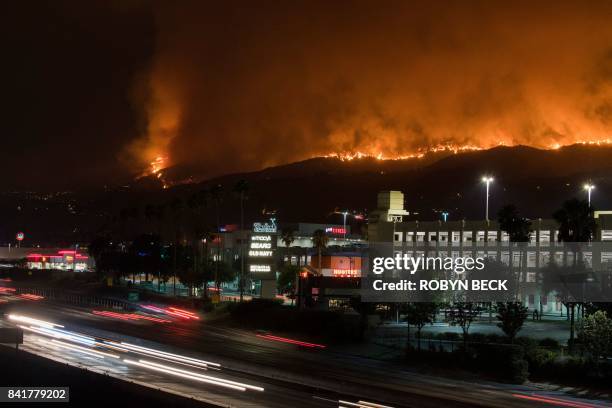 The La Tuna Canyon fire burns in the hills above Burbank, California, early September 2, 2017. - The brush fire which quickly burned 2,000 acres...