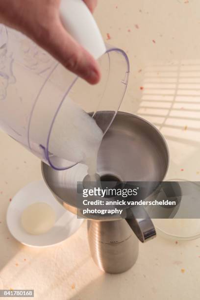 sauce made from agar and lime juice being poured in a gourmet whip. - petri schaal stockfoto's en -beelden