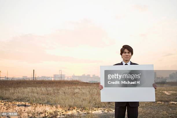 a businessman with the message board - placard stock pictures, royalty-free photos & images