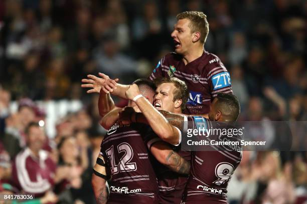 Curtis Sironen of the Sea Eagles is congratulated by Jake Trbojevic of the Sea Eagles and team mates after scoring a try during the round 26 NRL...