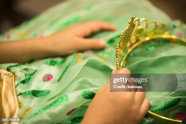 a small girl is sitting with a tiara. - kids tiara stock pictures, royalty-free photos & images