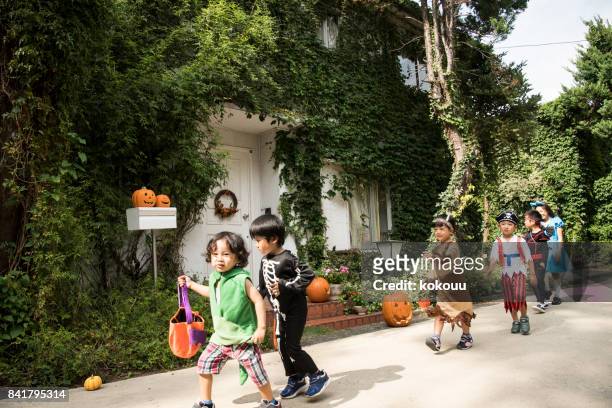 children marching in front of the house wearing costumes. - princess pirates stock pictures, royalty-free photos & images