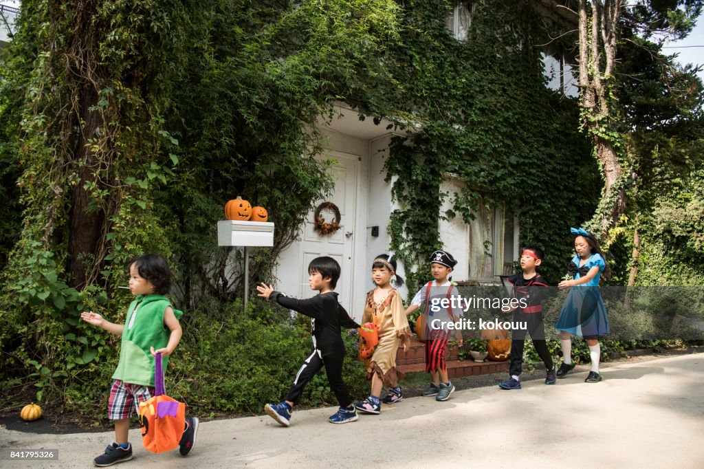 Bambini che marciano davanti alla casa indossando costumi.