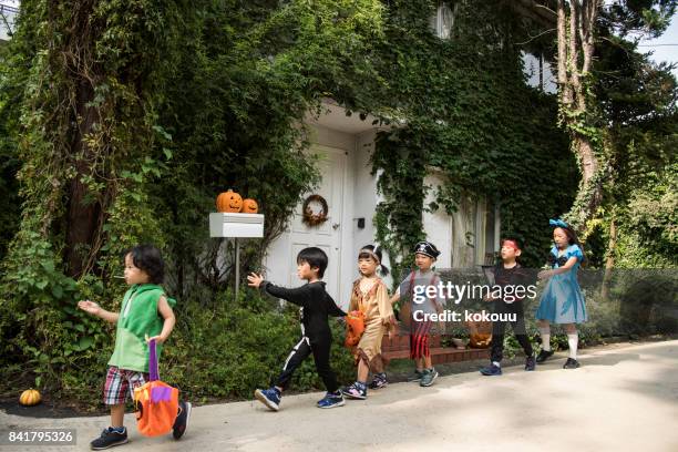 children marching in front of the house wearing costumes. - princess pirates stock pictures, royalty-free photos & images