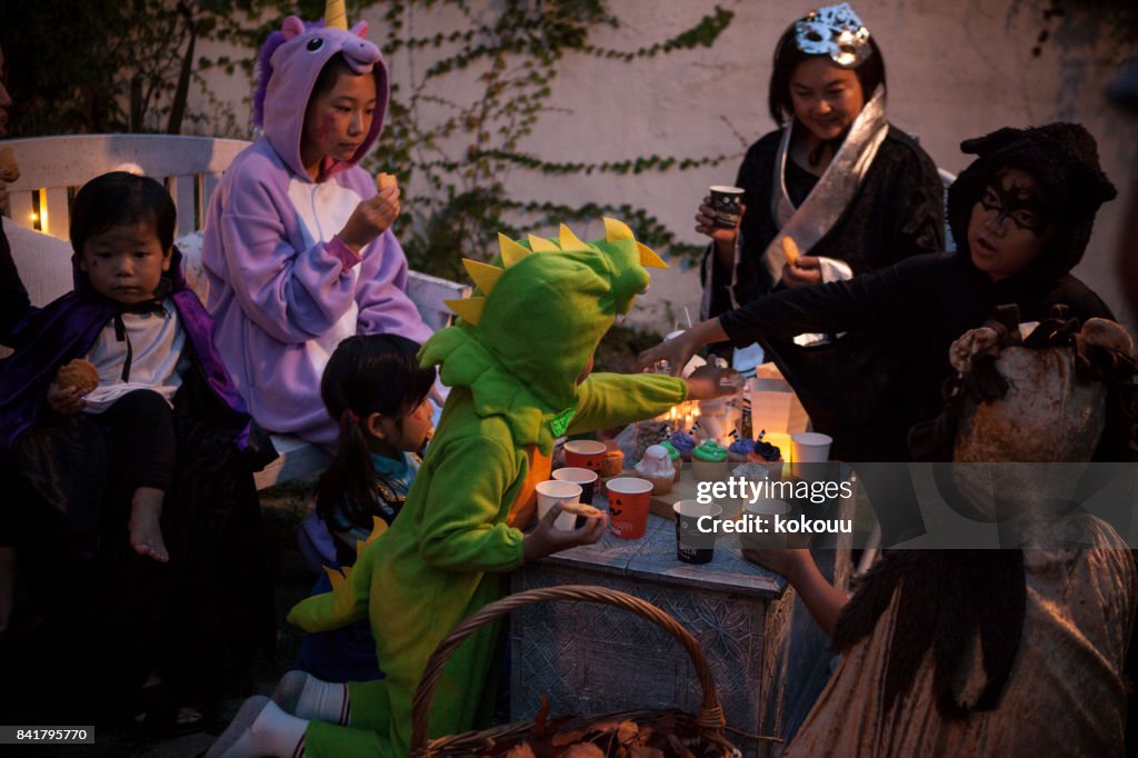 A family that is having a Halloween party in the garden.