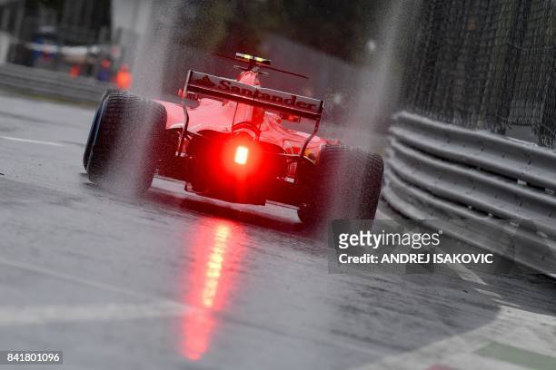 Ferrari's Finnish driver Kimi Raikkonen drives on a wet circuit during the third practice session at the Autodromo Nazionale circuit in Monza on...