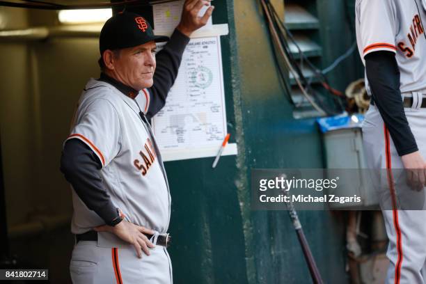 Pitching Coach Dave Righetti of the San Francisco Giants stands in the dugout during the game against the Oakland Athletics at the Oakland Alameda...