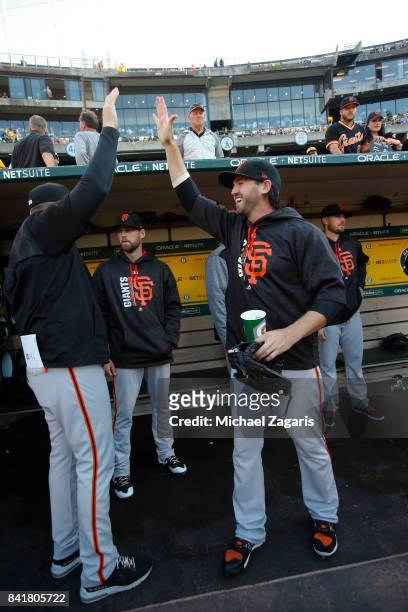 Cory Gearrin of the San Francisco Giants high-fives teammates in the dugout prior to the game against the Oakland Athletics at the Oakland Alameda...