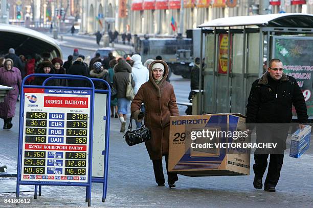 Belarus people walk past a currency exchange booth in Minsk on January 5, 2009. Belarus on January 2, 2009 devalued its ruble by more than a fifth...