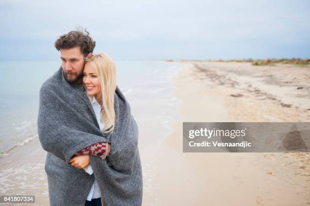 perfect winter vacation - romantic couple walking winter beach stock pictures, royalty-free photos & images