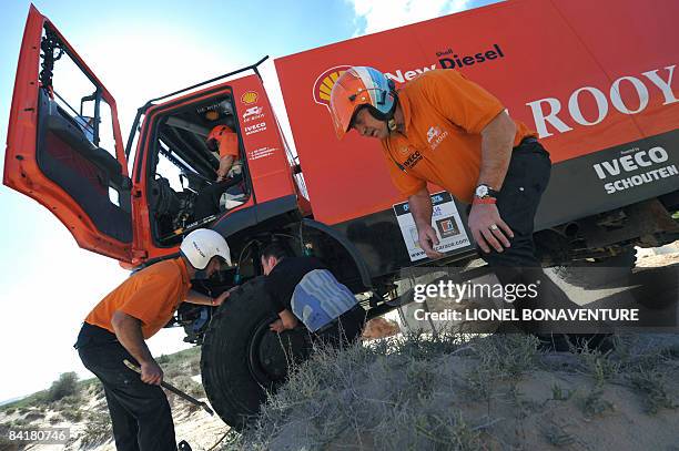 Dutch Hans Bekx helps Belgian Jan De Rooy to change his flat tyre during the sixth stage between Agadir and El Ayoun of the first edition of the...