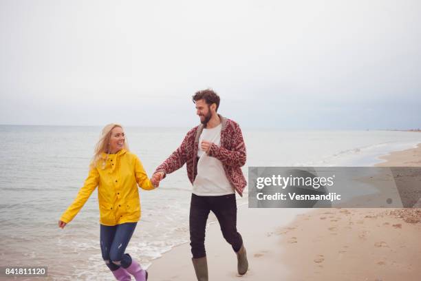 perfect winter vacation - romantic couple walking winter beach stock pictures, royalty-free photos & images