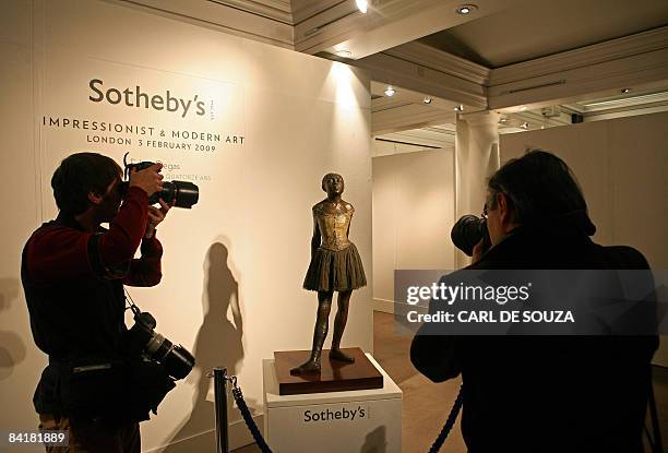 Photographers take pictures of a bronze cast sculpture entitled 'Petite danseuse de quatorze ans' by French artist Edgar Degas at Sothebys auction...