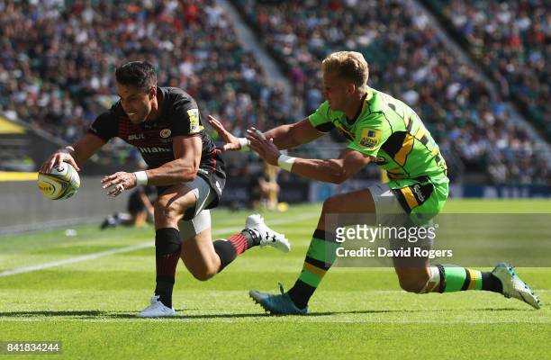 Sean Maitland of Saracens scores their third try as Harry Mallinder of Northampton Saints attempts to tackle during the Aviva Premiership match...