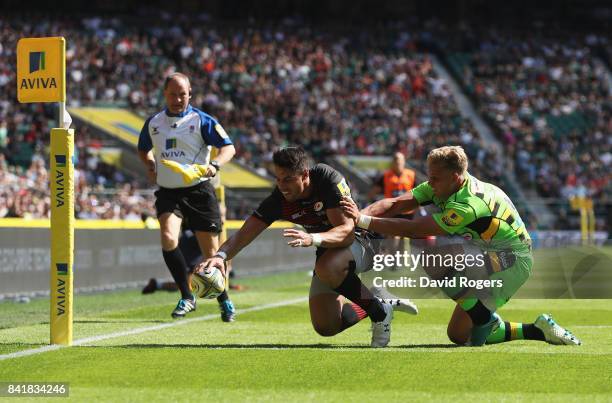 Sean Maitland of Saracens scores their third try as Harry Mallinder of Northampton Saints attempts to tackle during the Aviva Premiership match...