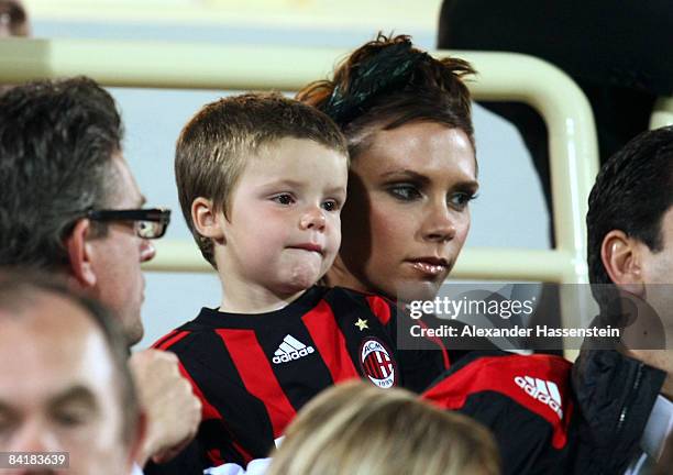 Victoria Beckham talks to her son Cruz during the Dubai Football Challenge match between AC Milan and Hamburger SV at the Emirates Sevens Stadium on...