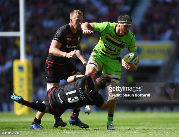 Tom Wood of Northampton Saints is tackled by Duncan Taylor of Saracens during the Aviva Premiership match between Saracens and Northampton Saints at...