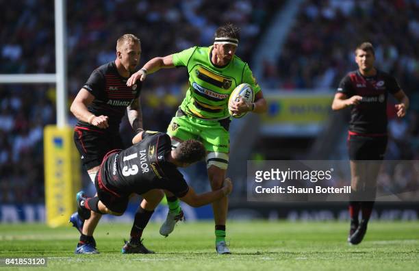 Tom Wood of Northampton Saints is tackled by Duncan Taylor of Saracens during the Aviva Premiership match between Saracens and Northampton Saints at...