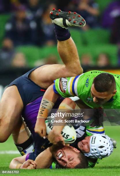 Kenneath Bromwich of the Storm is tackled during the round 26 NRL match between the Melbourne Storm and the Canberra Raiders at AAMI Park on...