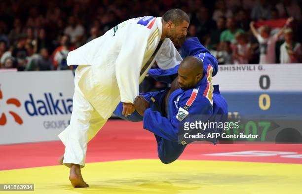 France's Teddy Riner competes with Guram Tushishvili of Georgia during their semi-final match in the mens +100kg category at the World Judo...