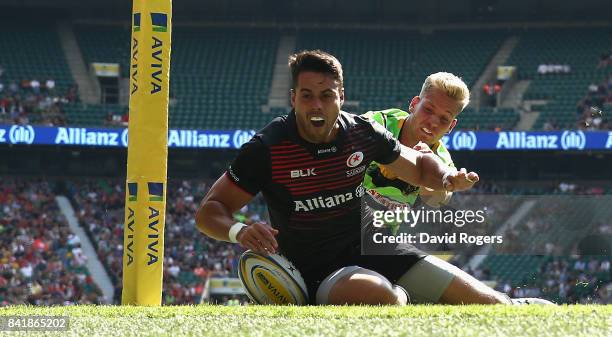 Sean Maitland of Saracens, despite being tackled by Harry Mallinder, scores his first try of a first half hatrick during the Aviva Premiership match...