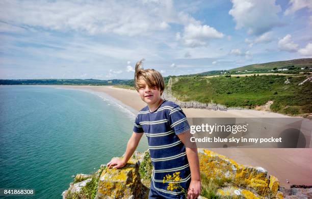 a young boy standing on a rocky outcrop. - portrait lachen stock pictures, royalty-free photos & images