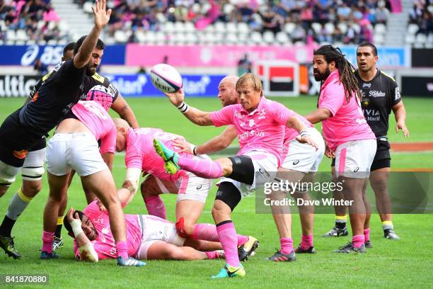 Charl McLeod of Stade Francais Paris kicks away under pressure from Romain Sazy of La Rochelle during the Top 14 match between Stade Francais and La...