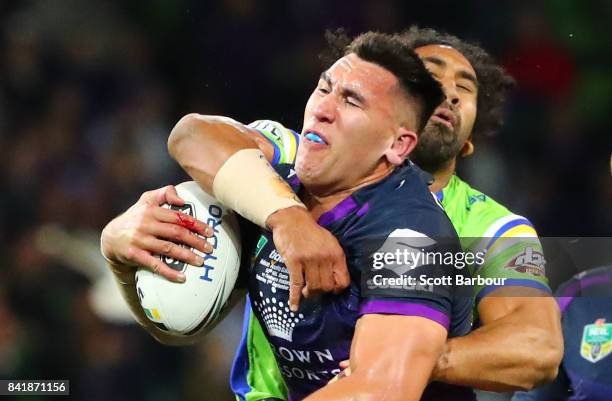 Nelson Asofa-Solomona of the Storm is tackled by Iosia Soliola of the Raiders during the round 26 NRL match between the Melbourne Storm and the...