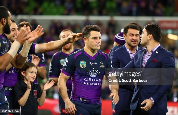 Cooper Cronk of the Storm is congratulated by his teammates after he played his final home match after the round 26 NRL match between the Melbourne...