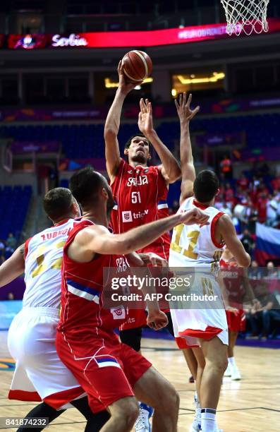 Serbia`s centre Boban Marjanovic shoots past Russia`s Semen Antonov and forward Andrey Zubkov during the FIBA Eurobasket 2017 men`s group D...
