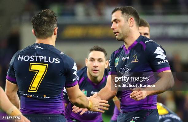 Cooper Cronk of the Storm is congratulated by Cameron Smith and Billy Slater after he played his final home match after the round 26 NRL match...