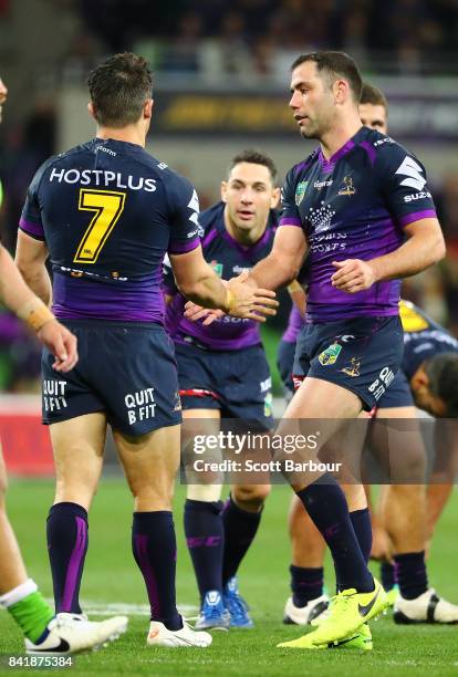 Cooper Cronk of the Storm is congratulated by Cameron Smith and Billy Slater after he played his final home match after the round 26 NRL match...