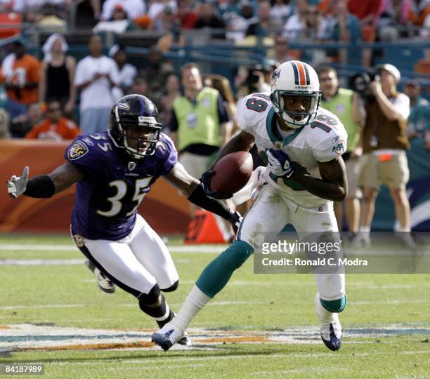 Ted Ginn Jr. #19 of the Miami Dolphins carries the ball as Corey Ivy of the Baltimore Ravens chases him during the AFC Wild Card Game at Dolphin...