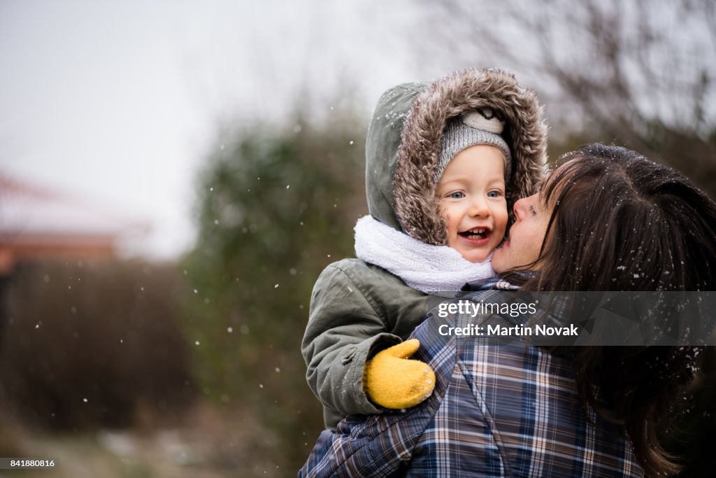 Smiling baby girl and mother in winter park