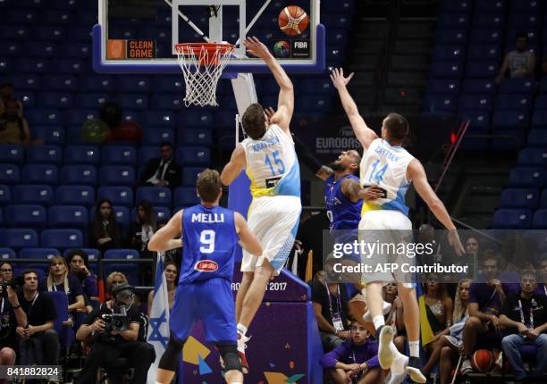 Ukraine's centre Viacheslav Kravstov defends the net as power forward Igor Zaytsev marks Italy's point guard Daniel Hackett , during their FIBA...