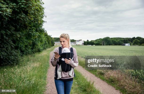 relaxed parenting walking through the field - baby carrier stock pictures, royalty-free photos & images