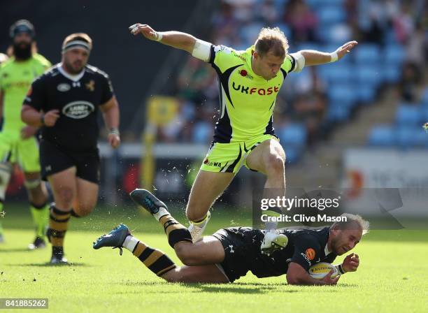 Will Addison of Sale Sharks jumps over Dan Robson of Wasps during the Aviva Premiership match between Wasps and Sale Sharks at The Ricoh Arena on...