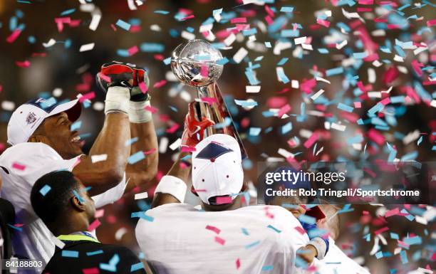 Defensive lineman Michael Strahan and Wide receiver Plaxico Burress of the New York Giants celebrate with the Lombardi trophy after defeating the New...
