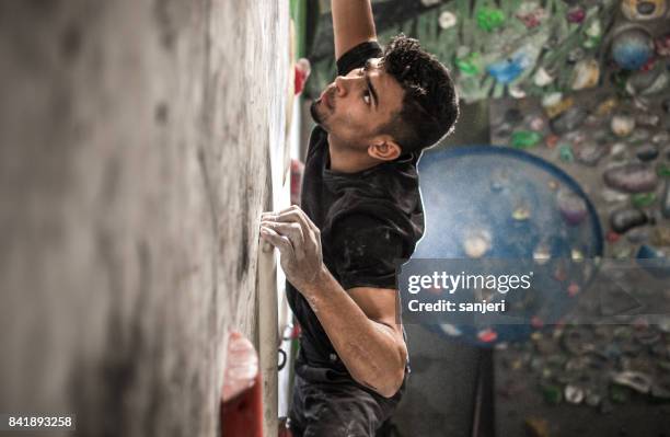 athlete climbing in a bouldering gym - chalk wall stock pictures, royalty-free photos & images