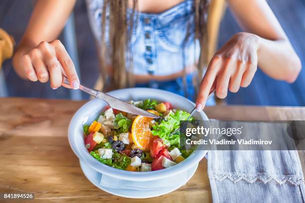 jonge vrouw salade eten voor de lunch - eating salad stockfoto's en -beelden