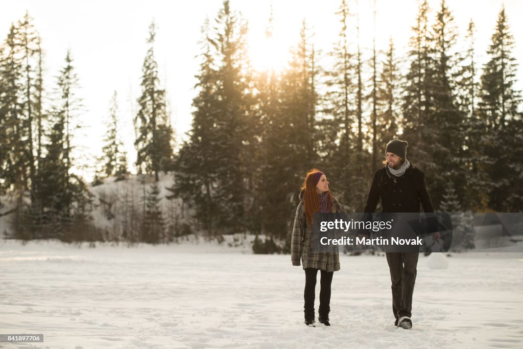 Couple holding hands and walking in winter park