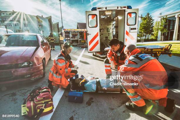 proporcionar primeros auxilios de paramédicos - accidente de tráfico fotografías e imágenes de stock