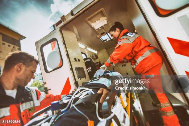 squadra paramedica che spinge barella - occupazione nei servizi di salvataggio foto e immagini stock