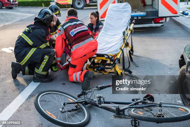 rettungs-team helfen radfahrer - unfall ereignis mit verkehrsmittel stock-fotos und bilder