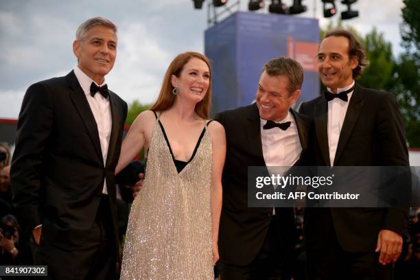 Actor and director George Clooney, US actess Julianne Moore, US actor Matt Damon and French composer Alexandre Desplat attend the premiere of the...